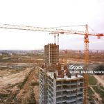 Tower crane at construction and the built environment. Crane during formworks on construction site. Pouring concrete into formwork. Construction the buildings and multi-storey residential homes.